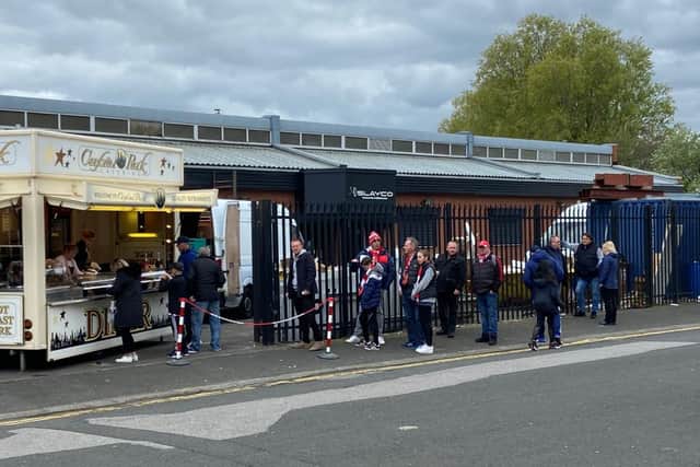 People queue up for something to eat outside the stadium.
