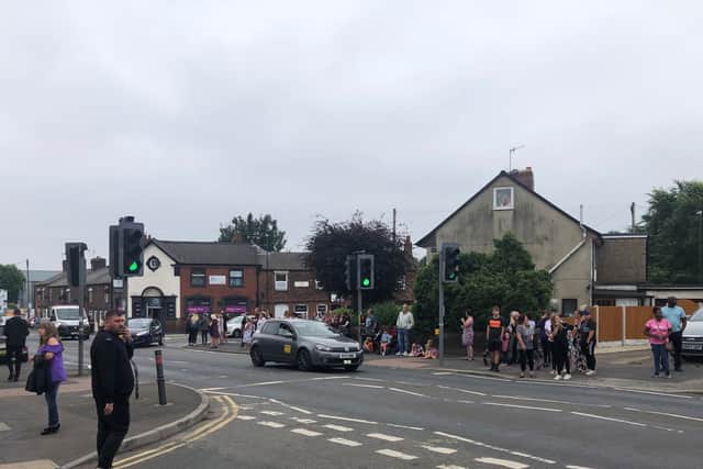 People wait for the funeral procession to pass through Old Whittington.
