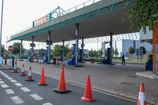 A petrol station forecourt is marked with traffic cones signalling there is a fuel shortage 