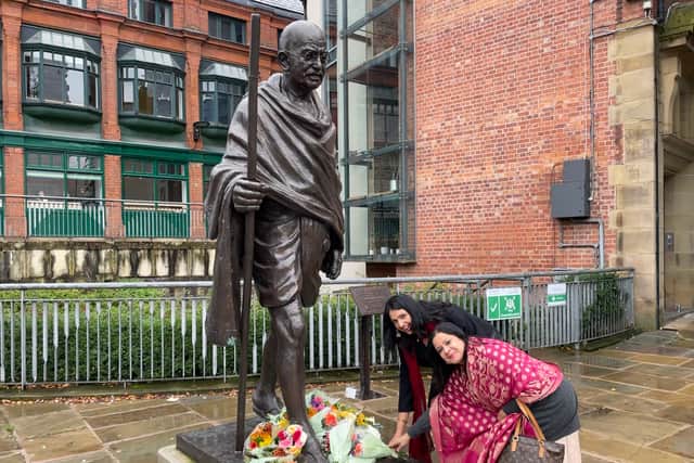 Flowers are laid at the foot of the statue of Gandhi in front of Manchester Cathedral 