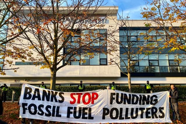 Extinction Rebellion protesters with a sign reading “Banks stop funding fossil fuel  polluters” 