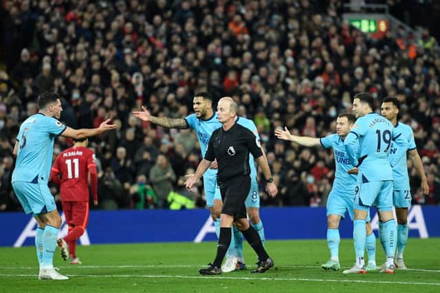 Newcastle United surround referee Mike Dean after protests over Liverpool’s equaliser. 