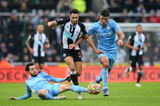 Jacob Murphy of Newcastle United is challenged by Bernardo Silva and Rodrigo of Manchester City during the Premier League match between Newcastle United and Manchester City 