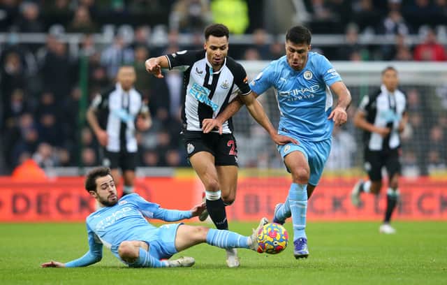 Jacob Murphy of Newcastle United is challenged by Bernardo Silva and Rodrigo of Manchester City during the Premier League match between Newcastle United and Manchester City 