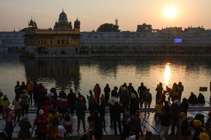 Devotees pay their respects during the last sunset of 2021 at the Sikh shrine Golden Temple in Amritsar