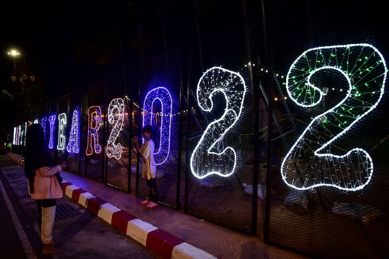 People take photos with light decorations ahead of the new year in the southern Thai province of Narathiwat