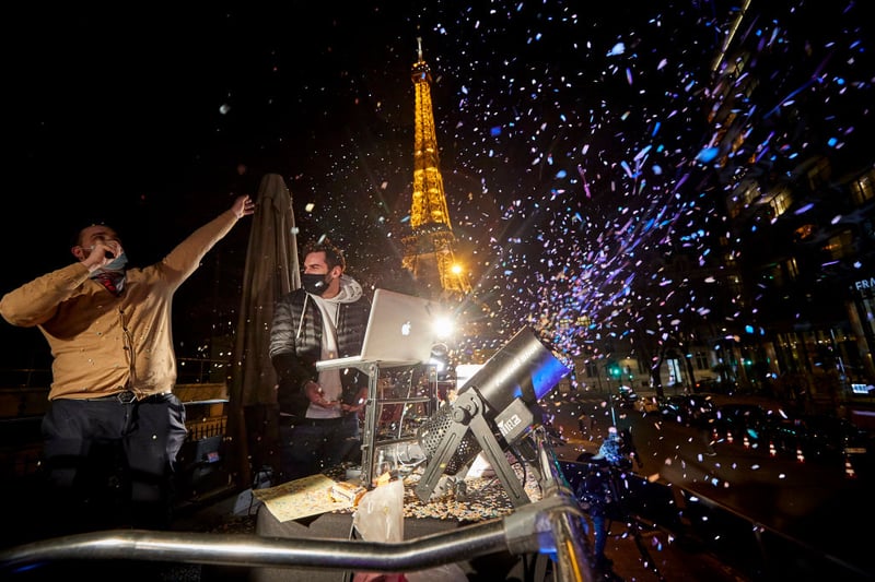 DJ Numa A Tfive celebrates the New Year in front of the Pullman Hotel at the near the Eiffel Tower. New Year’s eve celebrations and fireworks were cancelled throughout France and an 8pm curfew imposed in a bid to curb the spread of Covid-19 infections