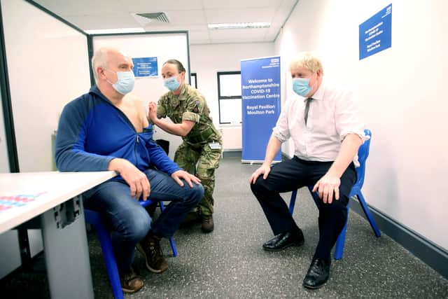 Prime Minister Boris Johnson looks on while Gordon Halfacre receives his coronavirus vaccine from corporal Lorna MacDonald (image: PA)