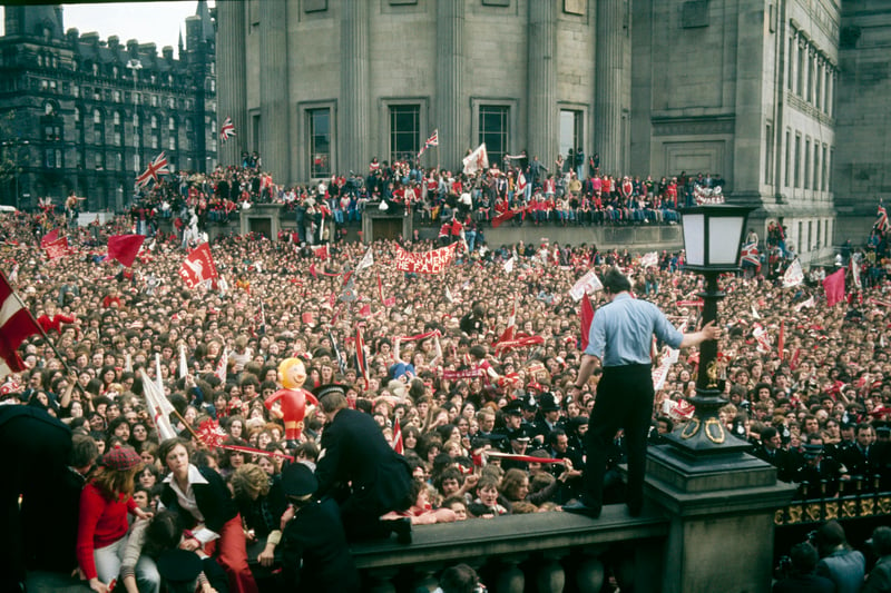 Fans wait for Liverpool’s FA Cup winners to emerge outside the Picton Library, with St George’s Hall and Lime Street in background.