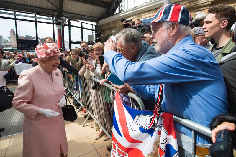 The Queen smiles as she is greeted by wellwishers after arriving by Royal Train at Liverpool Lime Street Station.