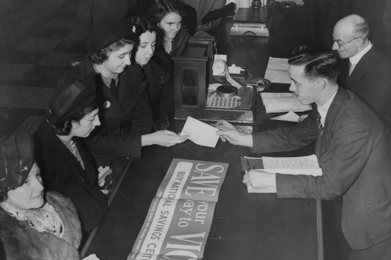 People queuing up to buy the new British government National Savings Certificates and Defence Bonds from a post office in Manchester 