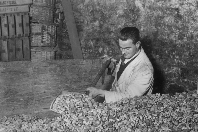 A worker mixing nuts for Christmas at Manchester Market in 1932