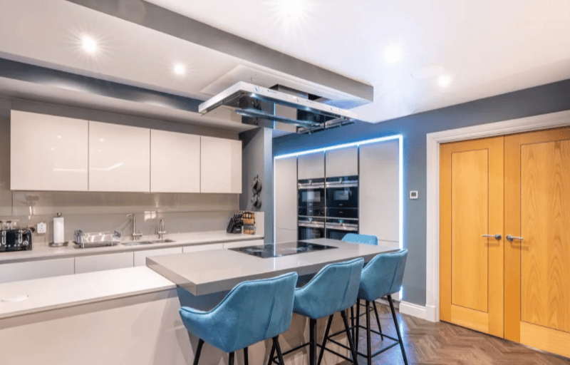 The colourful kitchen has lots of storage space and modern appliances.