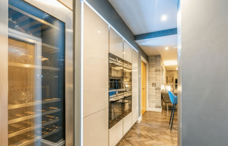 Extra storage coming off the side of the kitchen, including a wine fridge.