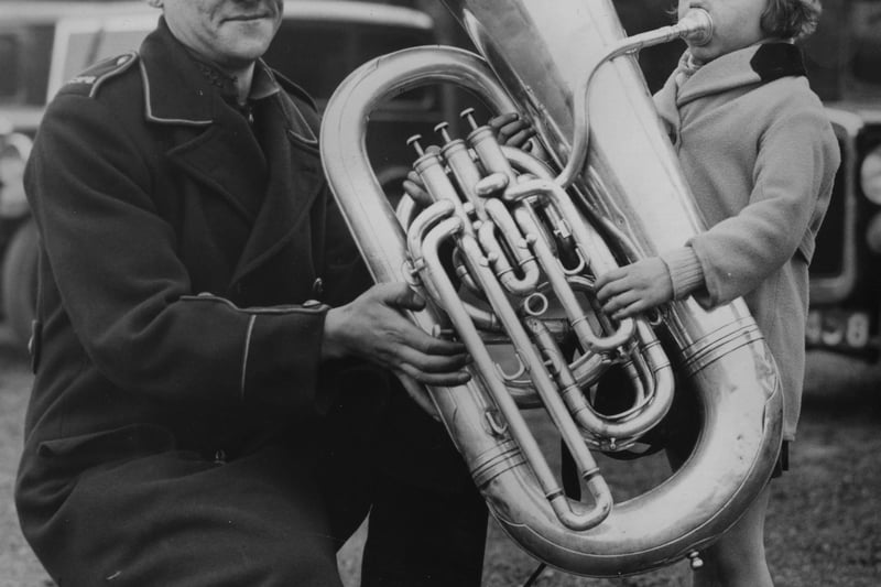 A member of the Clayton Silver Prize Band lets his daughter test her lungs on his tuba at the Annual May Championship Brass Band Festival at Belle Vue, Manchester, 1936.
