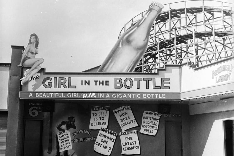 A fairground booth in Manchester’s Belle Vue advertises the ‘amazing’ phenomenon of the Girl in the Bottle, 1955