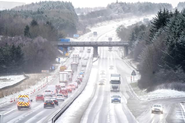 Motorists drive through the sleet and snow along the M8 motorway near Bathgate in West Lothian as Storm Eunice sweeps across the UK after hitting the south coast earlier on Friday.