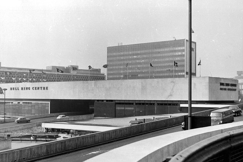 Cars drive through Birmingham city centre past the Bull Ring in 1965
