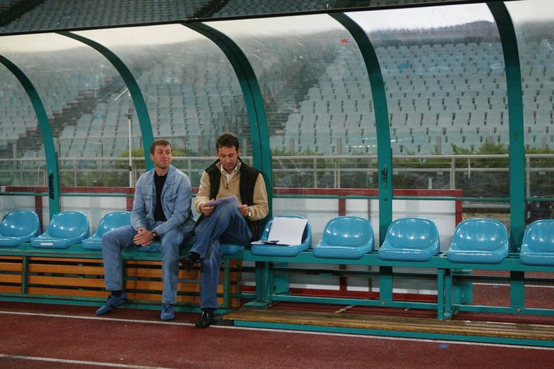 Roman Abramavich and Chelsea director Richard Creitzman watch from the dugout during the Chelsea training session prior to the Champions League First Stage Group G match 