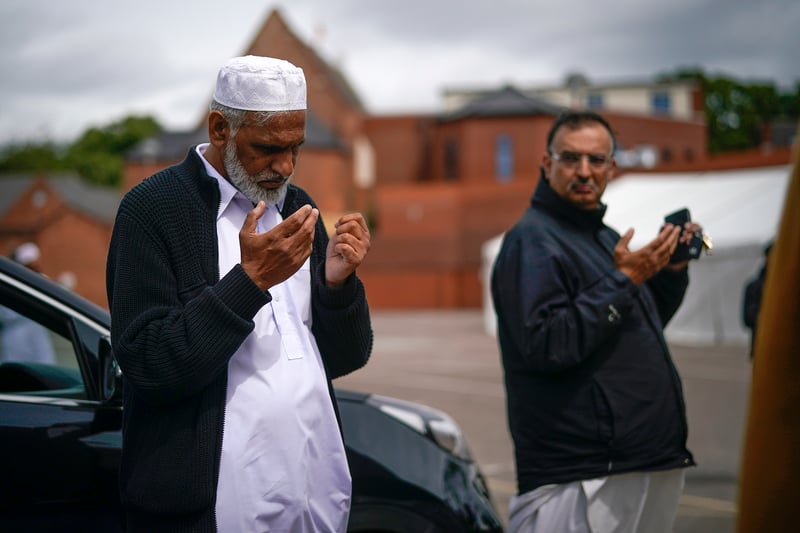  Family groups pray outside the locked Central Jamia Mosque Ghamkol Sharif, and listen to the Imam broadcasting the call to Dhur Prayers as the muslim community celebrate Eid under Covid-19 pandemic lockdown restrictions