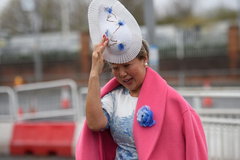 A horse racing fan showcases a stunning hat.