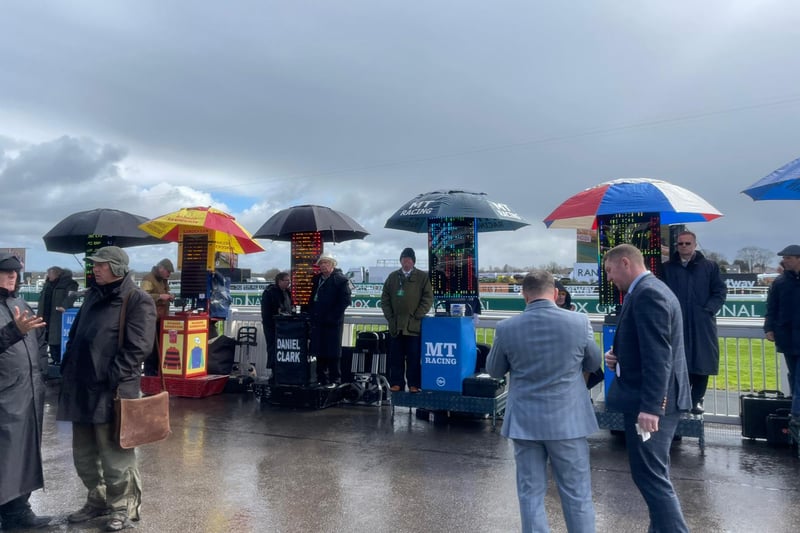 The bookies take refuge under their umbrellas at Aintree Racecourse.