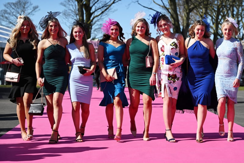 Racegoers pose for pictures upon their arrival to attend Ladies Day.