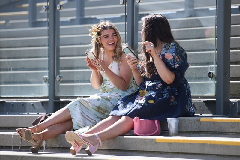 Two racegoers share a joke as they take a rest during Ladies Day.