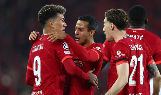 Roberto Firmino of Liverpool celebrates with Thiago Alcantara and Kostas Tsimikas after scoring their team's third goal  during the UEFA Champions League Quarter Final Leg Two match between Liverpool FC and SL Benfica at Anfield on April 13, 2022 in Liverpool, England. (Photo by Clive Brunskill/Getty Images)