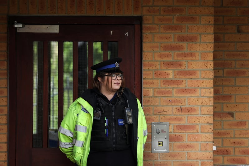 A police officer stands guard at the entrance to the flats. The force has upped patrols to provide reassurance to residents.