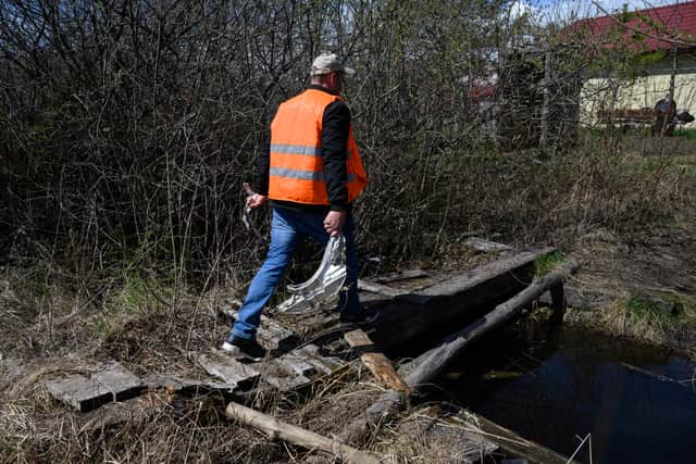 A man carries shards of twisted metal from a Russian rocket from fields near a train line on April 25, 2022 near Lviv, Ukraine (Photo: Getty)