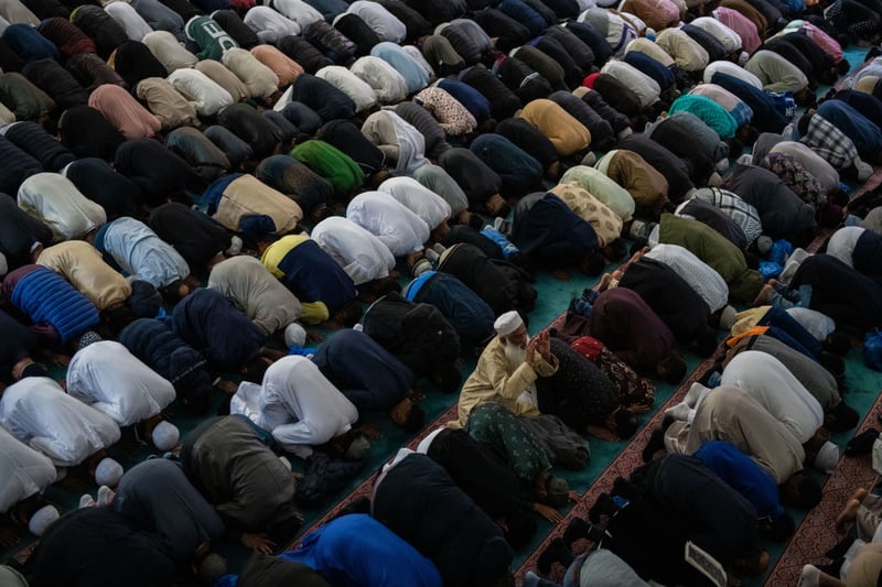 Men take part in morning prayers during Eid Al-Fitr celebrations at East London Mosque in Whitechapel 