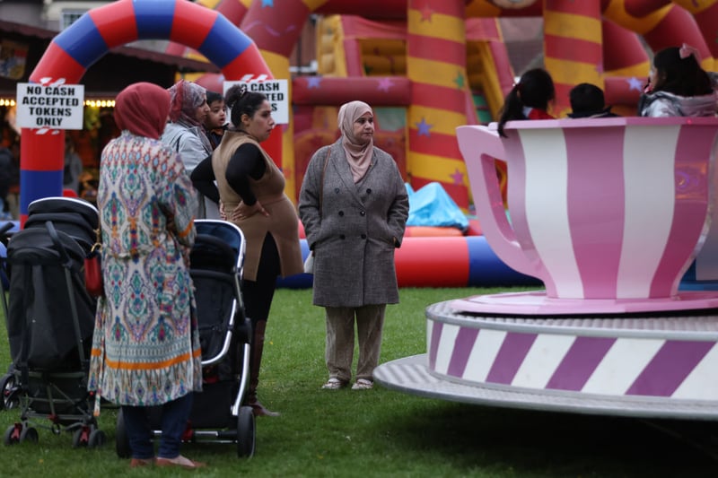 Women watch children on a carnival ride at an Eid fair in Goodmayes Park, Ilford on May 1 The fair was held to mark the end of Ramadan and the start of the Eid al-Fitr holiday.