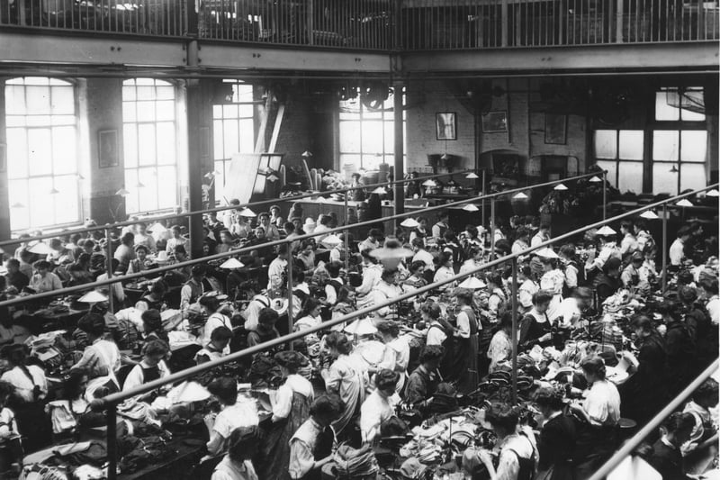 Women working in a crowded hatting factory in Manchester; date not stated.