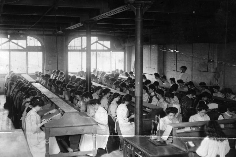 1st July 1909:  Women rolling tobacco by hand in a factory in Manchester