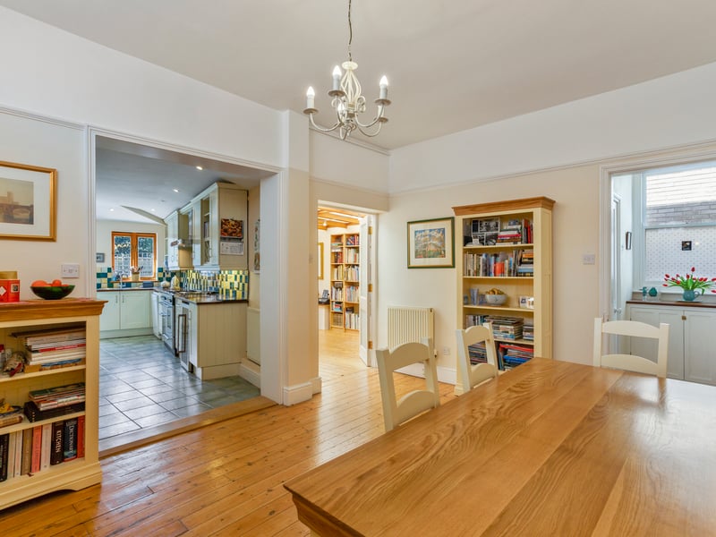 The dining room has a wooden floor and high level windows.