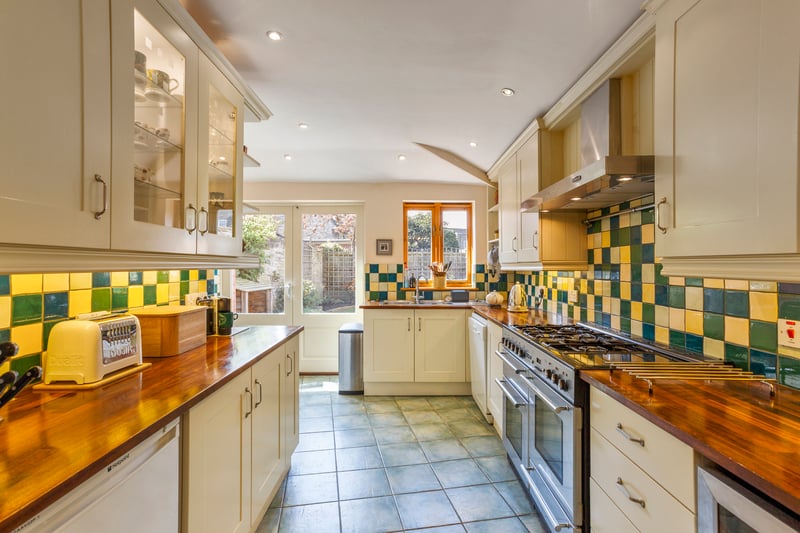 The tiled floored kitchen has a five-ring double oven gas range and double doors to the garden’s terrace.