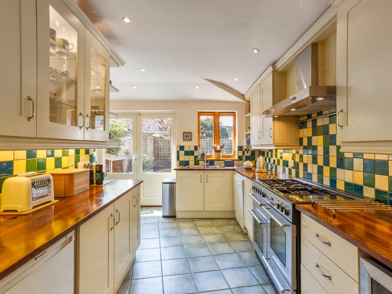 The tiled floored kitchen has a five-ring double oven gas range and double doors to the garden’s terrace.