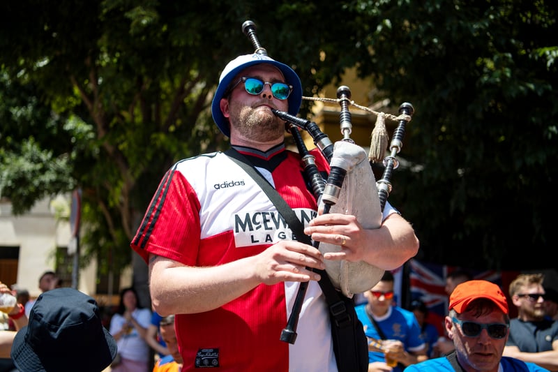 A fan plays the bagpipes ahead of the match.