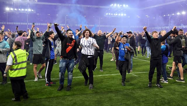 Everton fans celebrate on the pitch following their sides victory as they avoid relegation after the Premier League match between Everton and Crystal Palace at Goodison Park on May 19, 2022 in Liverpool, England. (Photo by Gareth Copley/Getty Images)