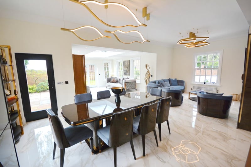 The dining area offers an abundance of space for a large family dining table with eight dining chairs and a sash window overlooking the garden.