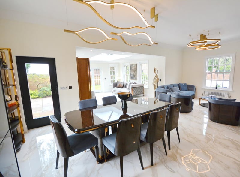 The dining area offers an abundance of space for a large family dining table with eight dining chairs and a sash window overlooking the garden.