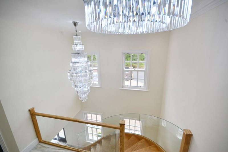 There are two chandeliers hanging from the landing ceiling, providing exceptional illumination to this area.