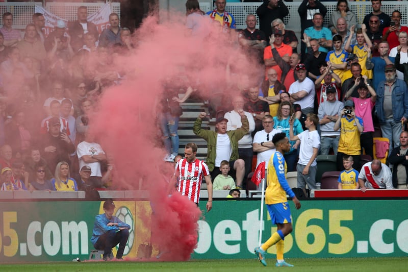  Christian Eriksen of Brentford removes a flare from the pitch during the Premier League match