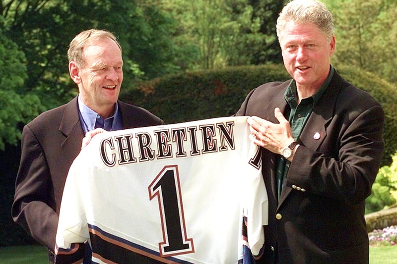US President Bill Clinton presents Canadian Prime Minister Jean Chretien with a Washington Capital hockey team jersey after winning a bet against the Ottawa Senators in the National Hockey League playoffs on May, 16, at the G-8 Summit leaders private retreat outside of Birmingham (Credit JOYCE NALTCHAYAN/AFP via Getty Images)