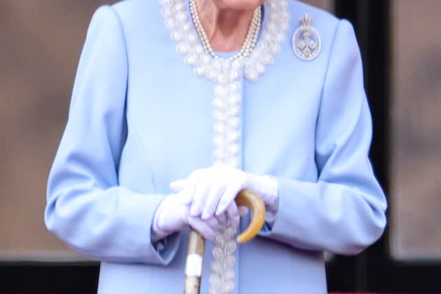 Queen Elizabeth II smiles as she watches from the balcony at Buckingham Palace 