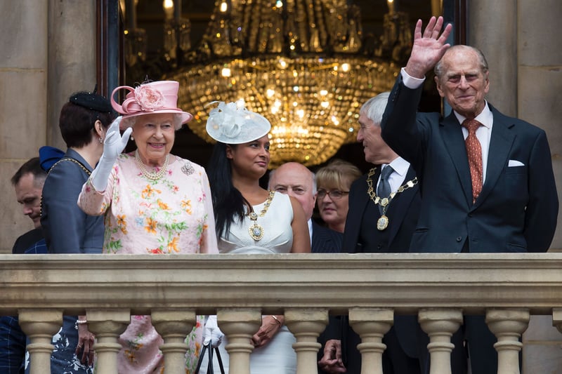 Queen Elizabeth II and her husband Prince Philip, Duke of Edinburgh waves to members of the public from the balcony of Liverpool Town Hall. 