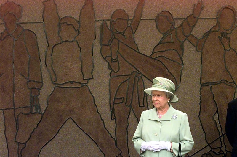 Queen Elizabeth II views a community wall sculpture during her visit to the St. Andrews Gardens Estate in Liverpool.