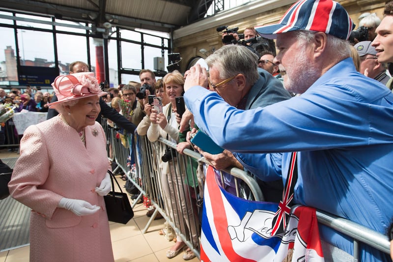 The Queen smiles as she is greeted by wellwishers after arriving by Royal Train at Liverpool Lime Street Station.