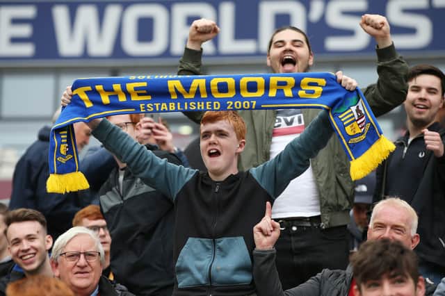 A fan of Solihull Moors shows their support with a scarf prior to kick-off 